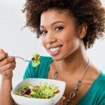 18325248 - close-up of beautiful african american woman eating salad at home